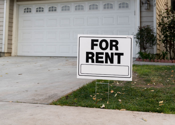 For rent sign in front of a house, representing a landlord scenario. For rent sign in front of a house, representing a landlord scenario.