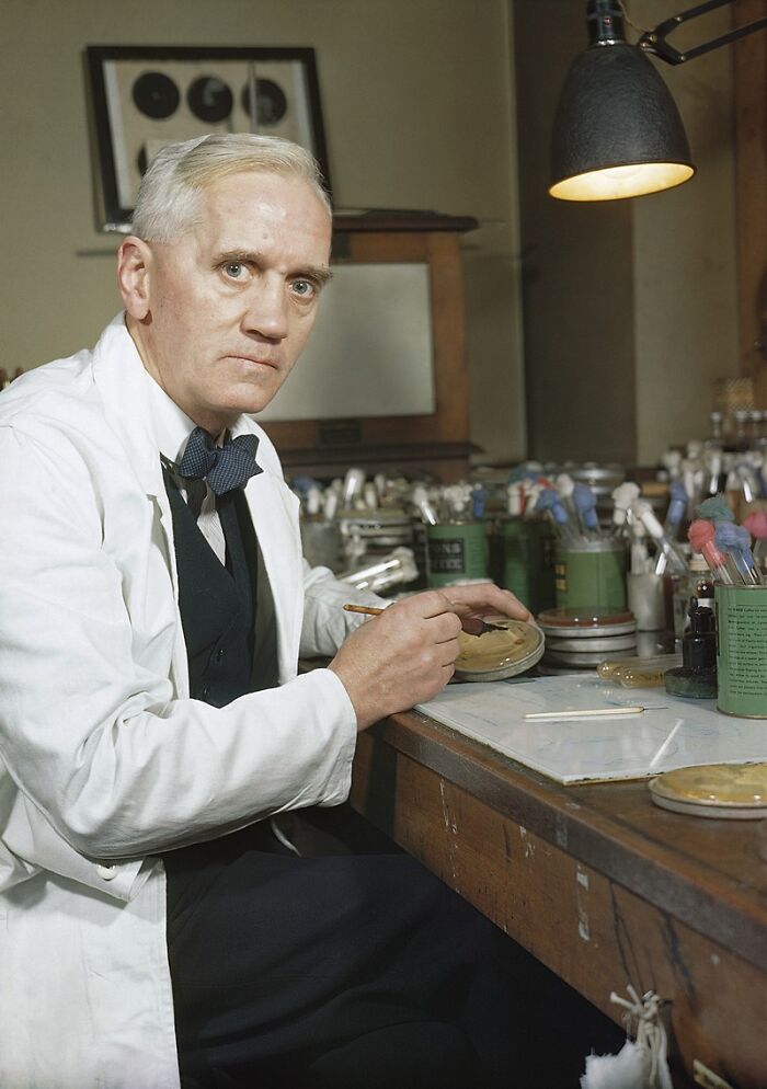 Scientist in a lab coat making last-minute decisions in a historical laboratory setting with scientific equipment.