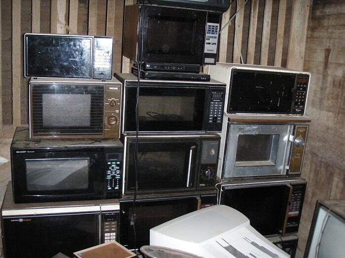 Stack of old microwave ovens in dim room, symbolizing last-minute decisions that changed the course of history.