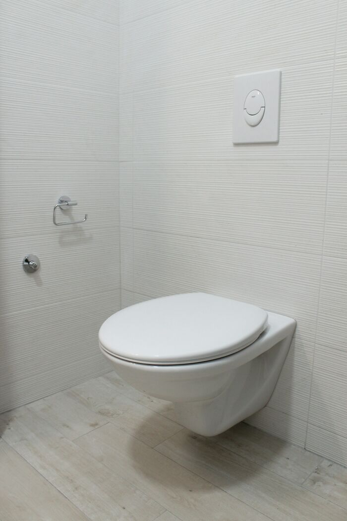 Modern bathroom with wall-hung toilet, highlighting impractical design in homes.