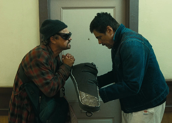 I don't know who these individuals are, but two men are interacting in a hallway, holding a large shoe form between them.