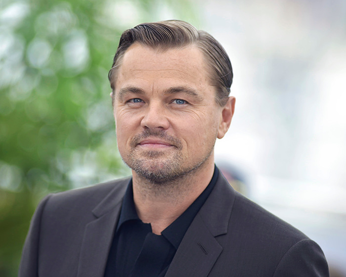 Man in a suit on a red carpet, showcasing a midlife crisis-inspired look.