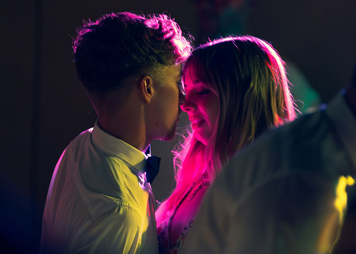 A couple dancing closely under colorful lights, illustrating lifestyle choices and red flags.