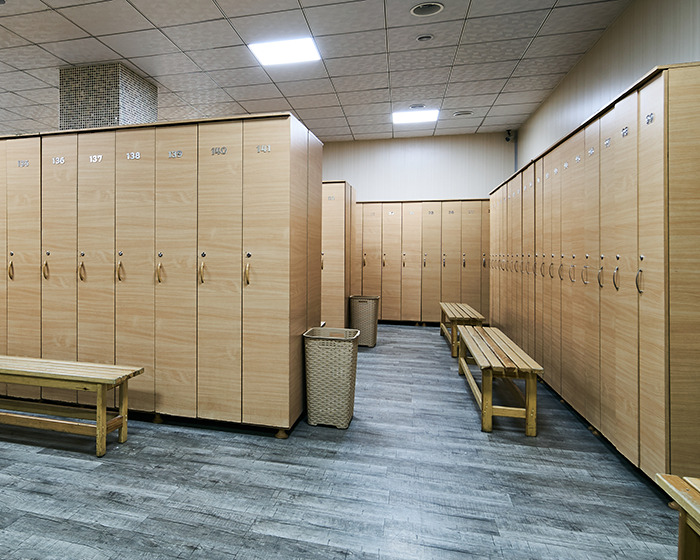 Empty locker room with wooden benches and lockers, related to trans locker room debate.