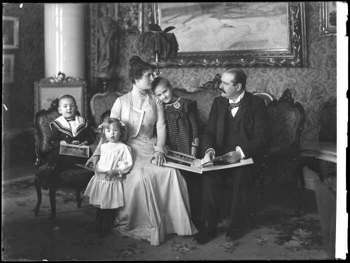 Vintage family portrait seated indoors, part of rare photographs restored from glass negatives showcasing history preserved.