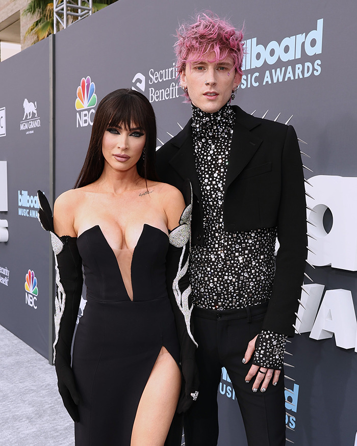 Machine Gun Kelly and Megan Fox at an event, posing on the red carpet in glamorous attire.