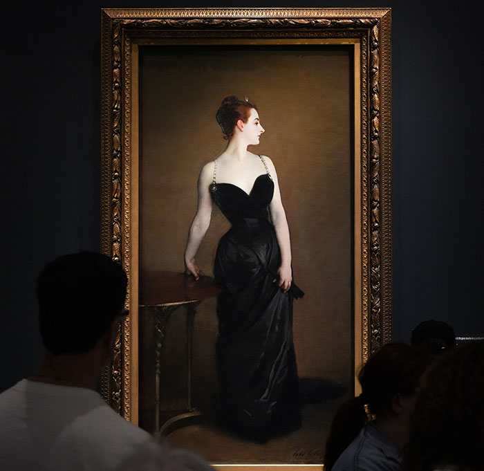 Painting at the Metropolitan Museum of Art, featuring a woman in a black dress, attracting curious onlookers.