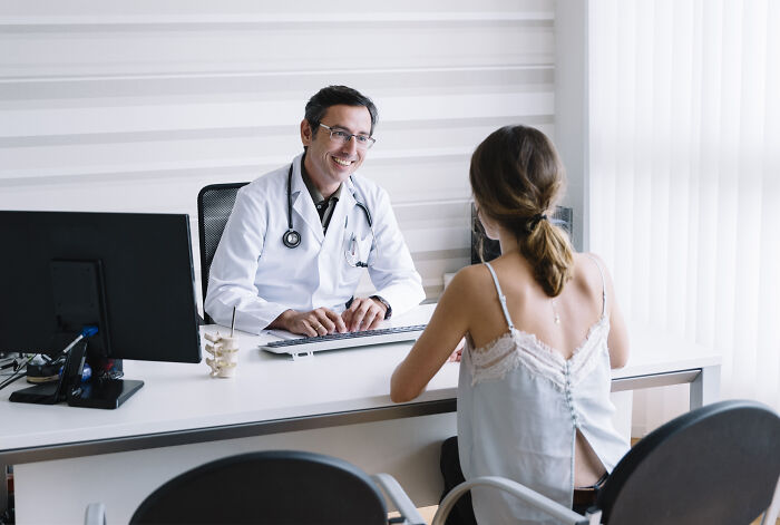Doctor smiling at patient during medical consultation in Europe.