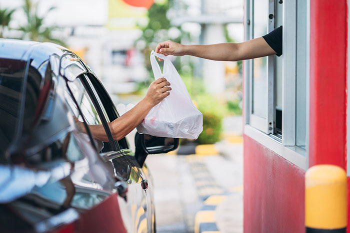 Driver receives a takeout bag at a drive-thru, illustrating a moment of petty revenge against an arrogant driver.