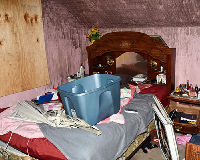 Cluttered bedroom scene related to man held captive by stepmom for 20 years.