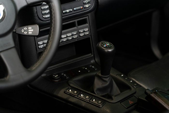 Car interior with focus on manual gear shift and dashboard controls, conveying the theme be present and mindful.