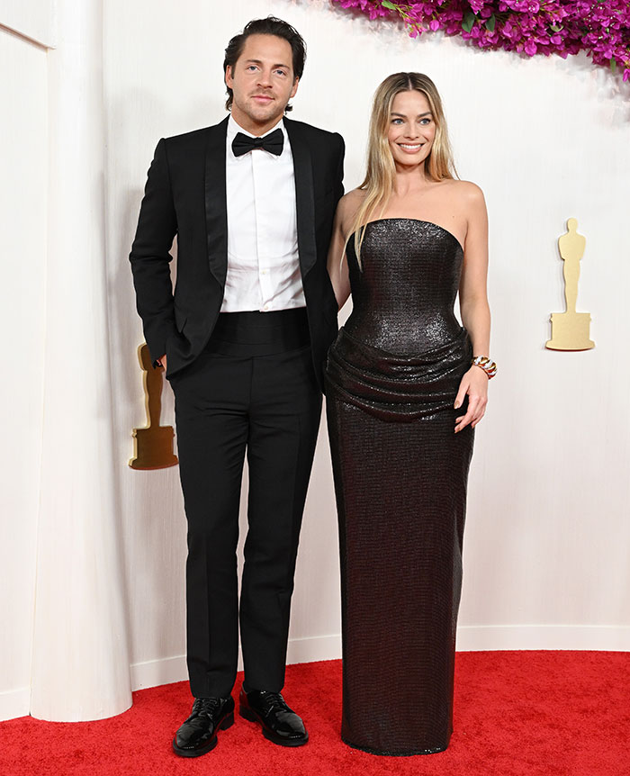 Woman in a black strapless dress on the red carpet, showcasing postpartum body confidence.