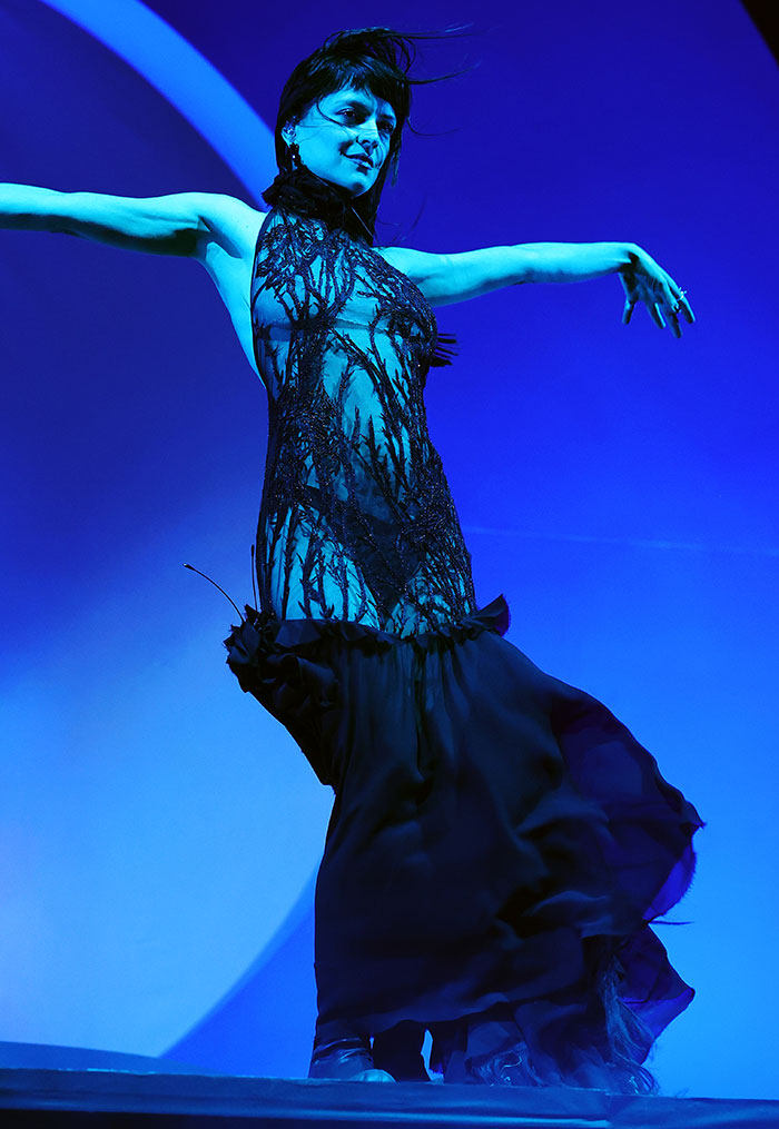 Celebrity in a dramatic black dress on stage at Coachella 2025, showcasing bold fashion choices.