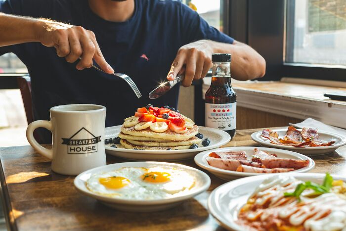 American breakfast with pancakes, eggs, bacon, and coffee, highlighting unique dining customs.