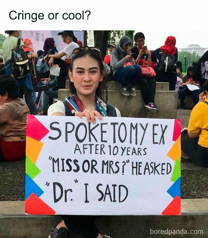Woman holding a colorful sign about medical school achievement, showcasing humor in a public setting.