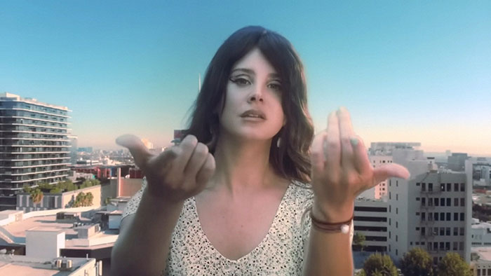 Woman gesturing on a rooftop with cityscape in the background, related to celebrity encounters.