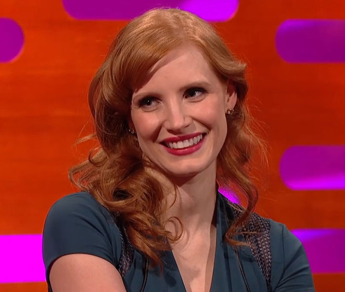 Smiling woman with red hair on a talk show set, representing memorable celebrity encounters.