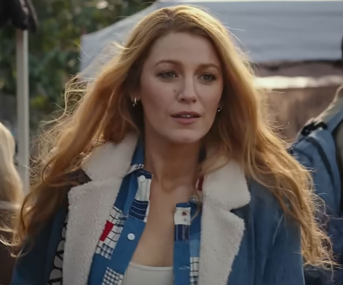 Woman with long hair in casual clothes outdoors, embodying celebrity style.