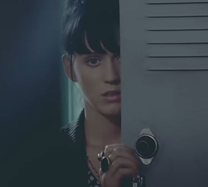 Person peeking through a partially open locker door in a dimly lit setting, evoking a sense of mystery and suspense in a celebrity context.