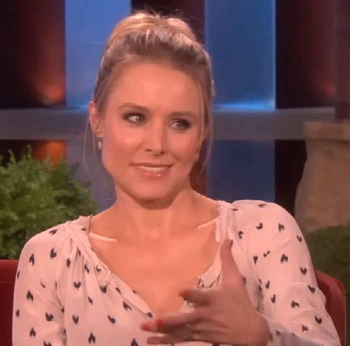 A person in a white patterned shirt is smiling while on a talk show, possibly describing a memorable celebrity encounter.