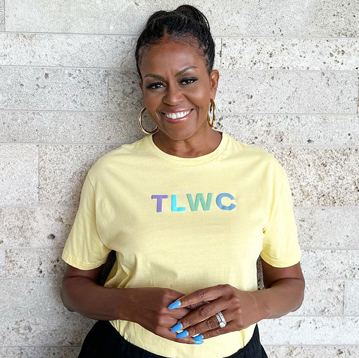 Woman in a yellow TLWC shirt, smiling against a stone wall, addressing divorce rumors for personal wellness. Woman in a yellow TLWC shirt, smiling against a stone wall, addressing divorce rumors for personal wellness.