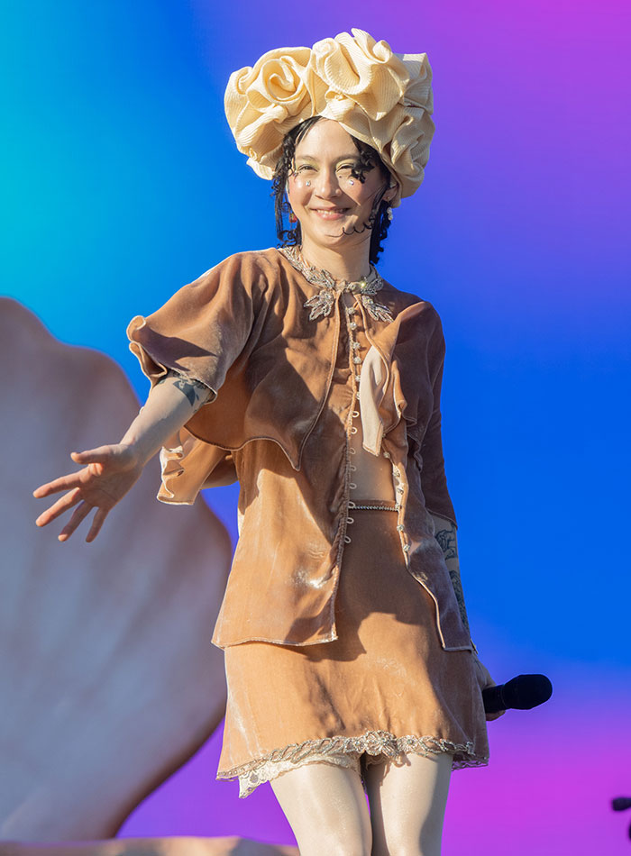 Celebrity in ornate outfit and headpiece at Coachella 2025, showcasing a unique fashion statement on stage.