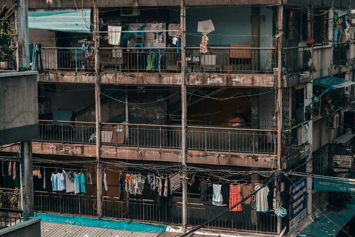 Old apartment building with clothes hanging on balconies, evoking survival instincts and caution.