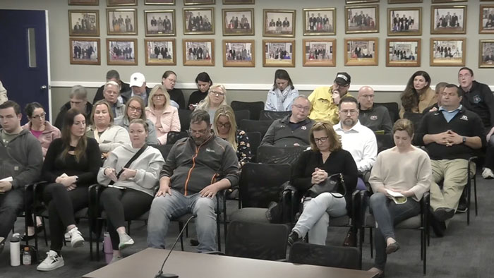 Parents at a meeting reacting to a middle school survey controversy.
