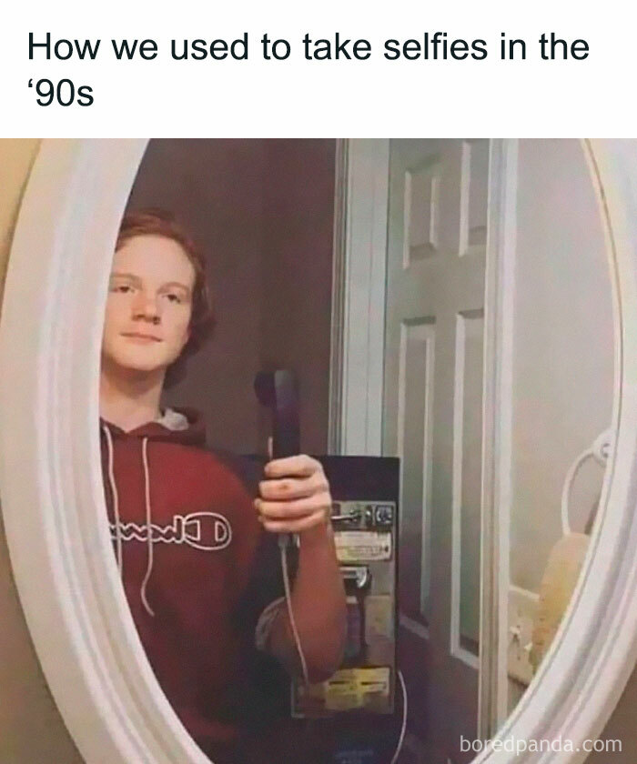 Teen uses payphone reflection for selfie, capturing millennial nostalgia humor.
