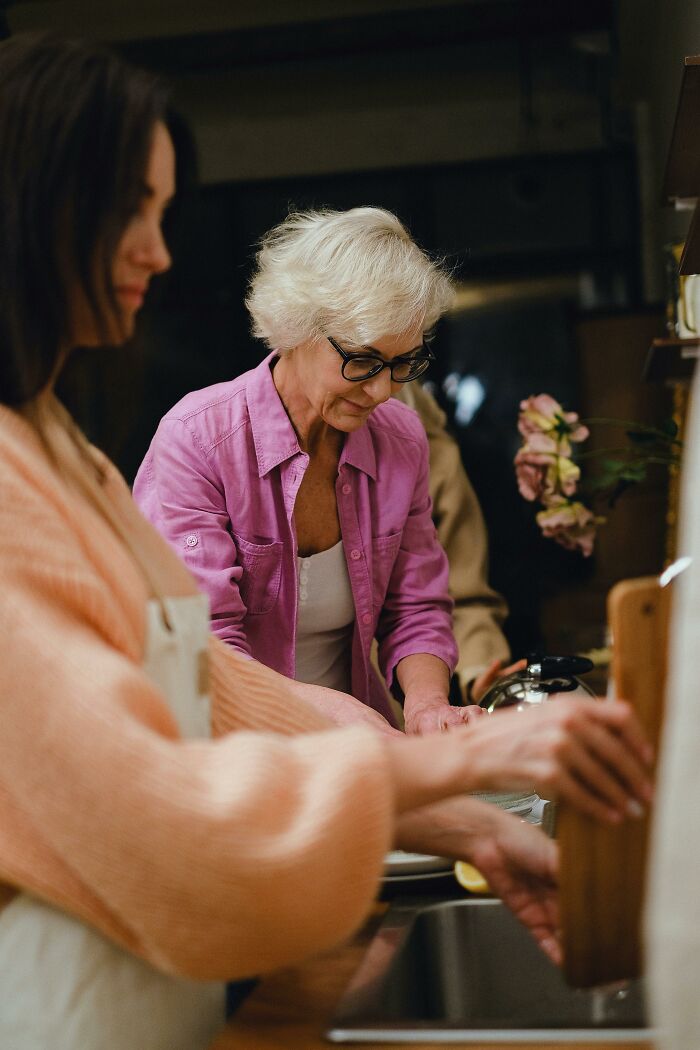 Elder millennials cooking together in a kitchen, highlighting community and shared experiences from the 2008 recession impact.