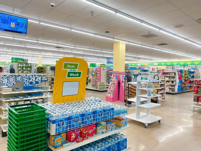 A well-lit dollar store aisle featuring bottled water and household items, illustrating post-2008 recession shopping trends.