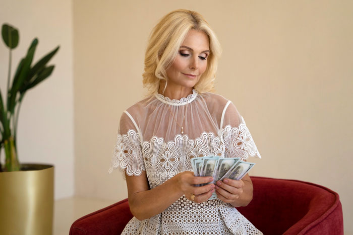 Woman in a lace dress counting money, symbolizing wedding reception payment and financial agreements.