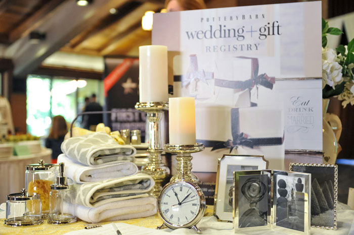 Wedding gifts on a table with candles and a clock, highlighted in a reception setting.