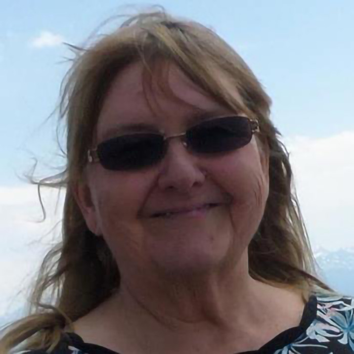 Smiling woman outdoors wearing sunglasses. Smiling woman outdoors wearing sunglasses.