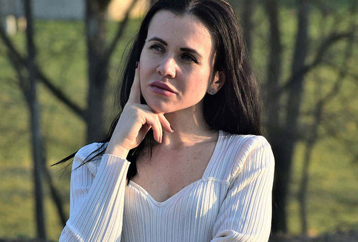 Woman contemplating in a park, related to stories about moms shamed by strangers.