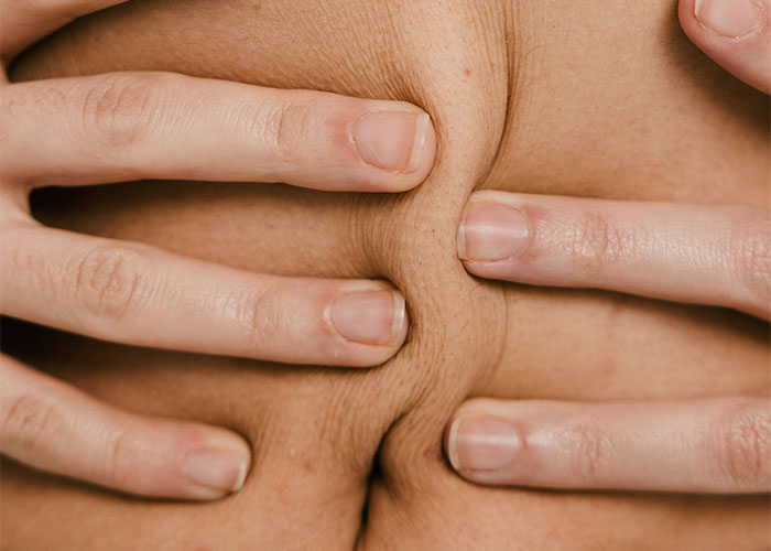 Hands pinching skin, illustrating vile family actions theme.