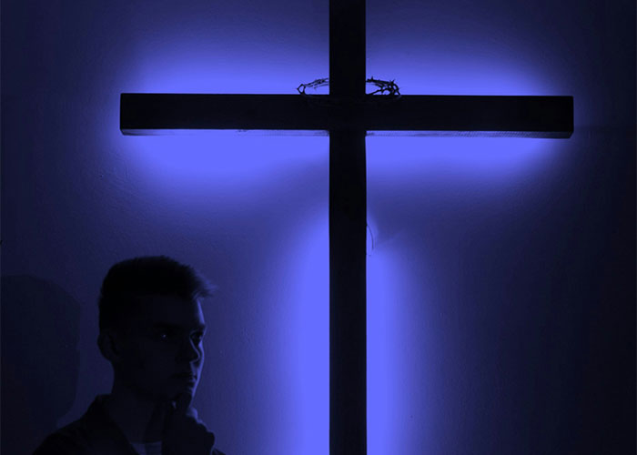 Silhouette of a person beside a glowing cross, evoking themes of vile family dynamics.
