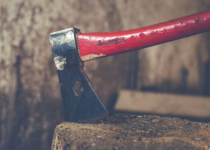 Axe with red handle embedded in wood, symbolizing vile actions in some families.