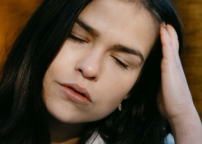 Woman looking stressed and touching her head, expressing frustration over unhinged family situations.