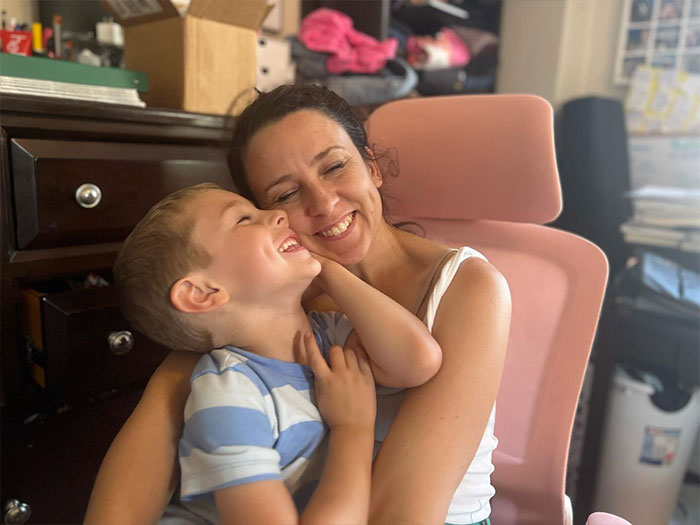 Ms. Rachel smiling with a child in her lap, sitting in a cozy home office, symbolizing Ms. Rachel's success story.