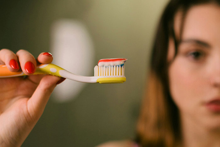 A person holding a toothbrush with toothpaste, highlighting marketing lies in product sales.