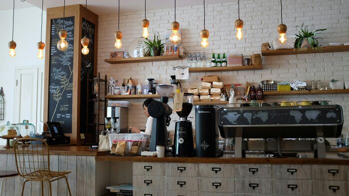 Cozy café interior with industrial lighting, chalkboard menu, and barista scene, reflecting relaxed ambiance and style.