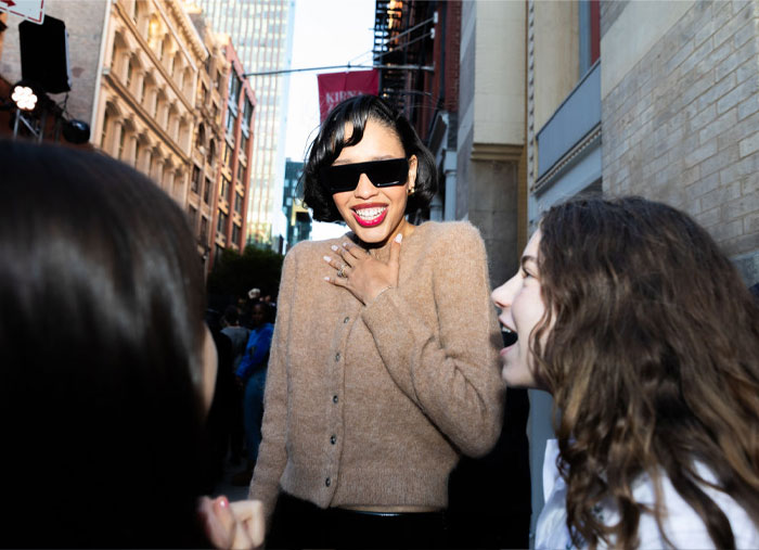 Nara Smith smiling and interacting with friends on a city street, embodying composure and youthfulness.
