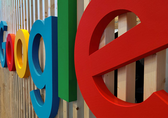 Colorful Google logo signage on a wooden wall, representing the tech giant's influence in Silicon Valley.