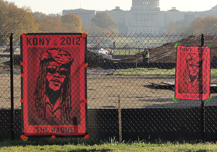 Red "Kony 2012" posters on a fence near the Capitol, symbolizing a flop in social activist movements.