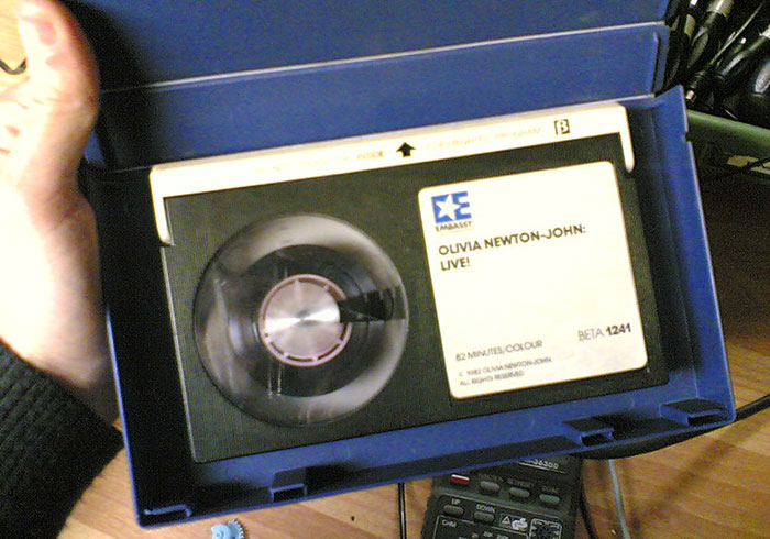 Beta videotape labeled "Olivia Newton-John: Live!" in a blue case, illustrating a past flop in media formats.