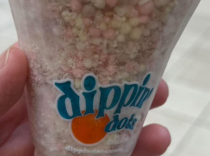 A hand holding a cup of Dippin' Dots, a product once considered the next big thing.