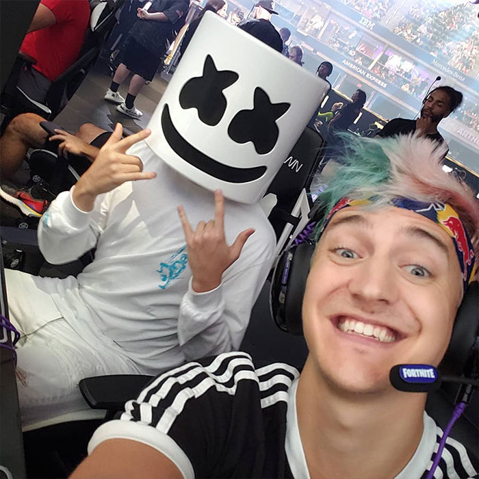 Streamer Ninja at an event, smiling with a friend in a playful mask, illustrating Ninja's increasing net worth in gaming.