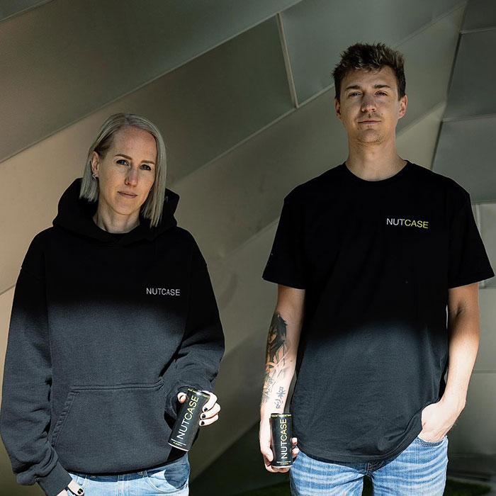 Two people including Ninja in Nutcase apparel holding cans, symbolizing Ninja's 2025 net worth growth through diverse ventures.