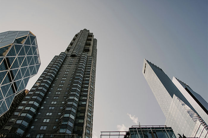 Looking up at tall skyscrapers representing US culture and architecture from a traveler's perspective.
